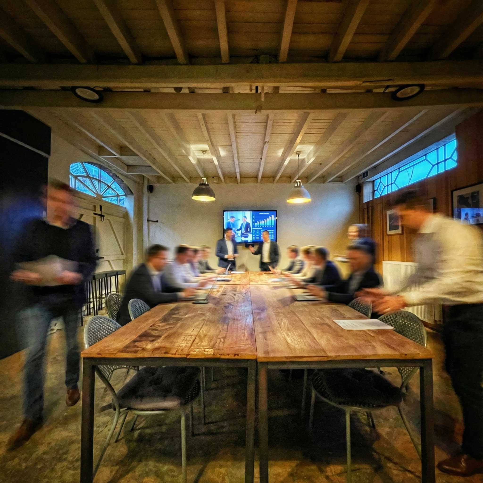 Zakelijke bijeenkomst in de wijnzaal van De Proeverij met presentatiescherm