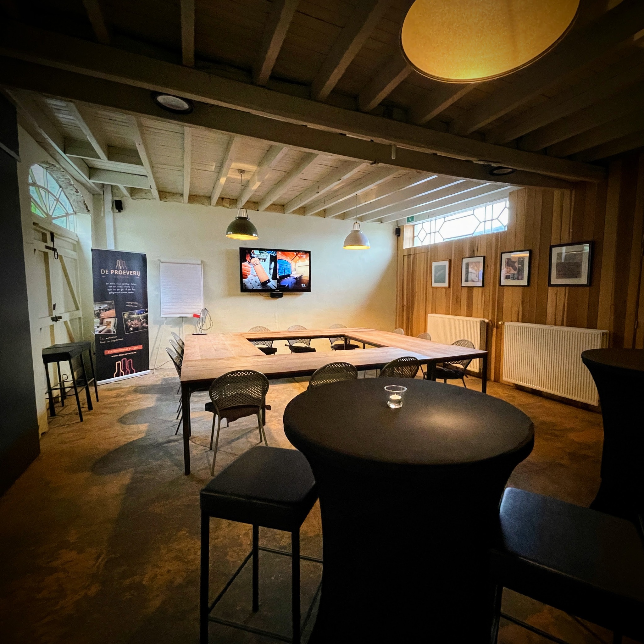Authentieke zaal van De Proeverij in meetingopstelling met warme verlichting en houten tafels