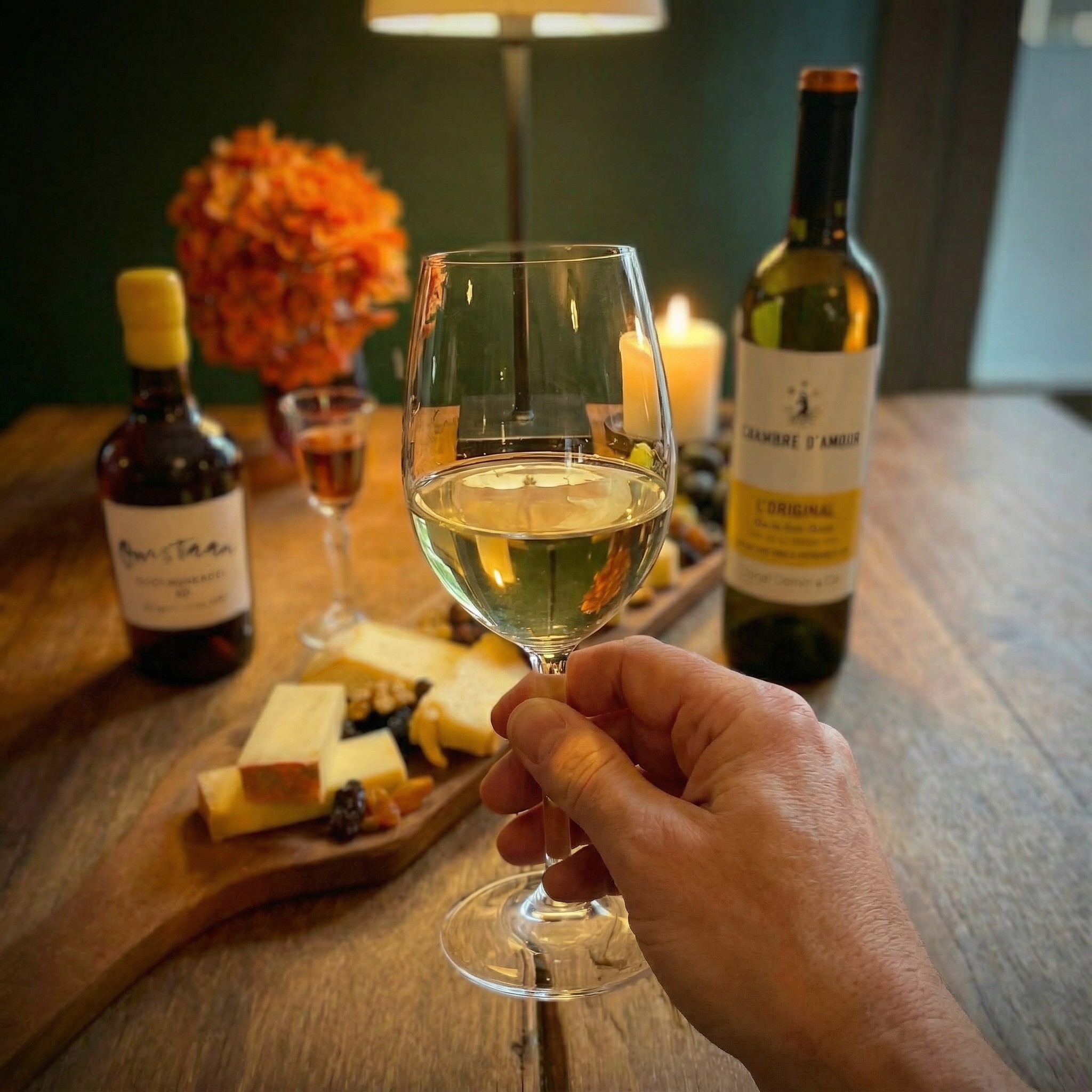 Glas witte wijn met kaasplank in De Proeverij